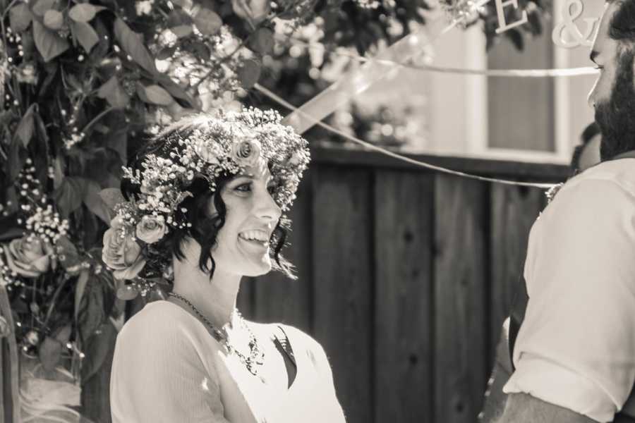 Bride with cancer smiles at wedding ceremony wearing flower crown