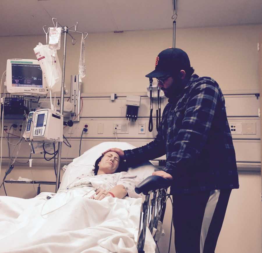 Man stands beside fiancee in hospital bed who has cancer