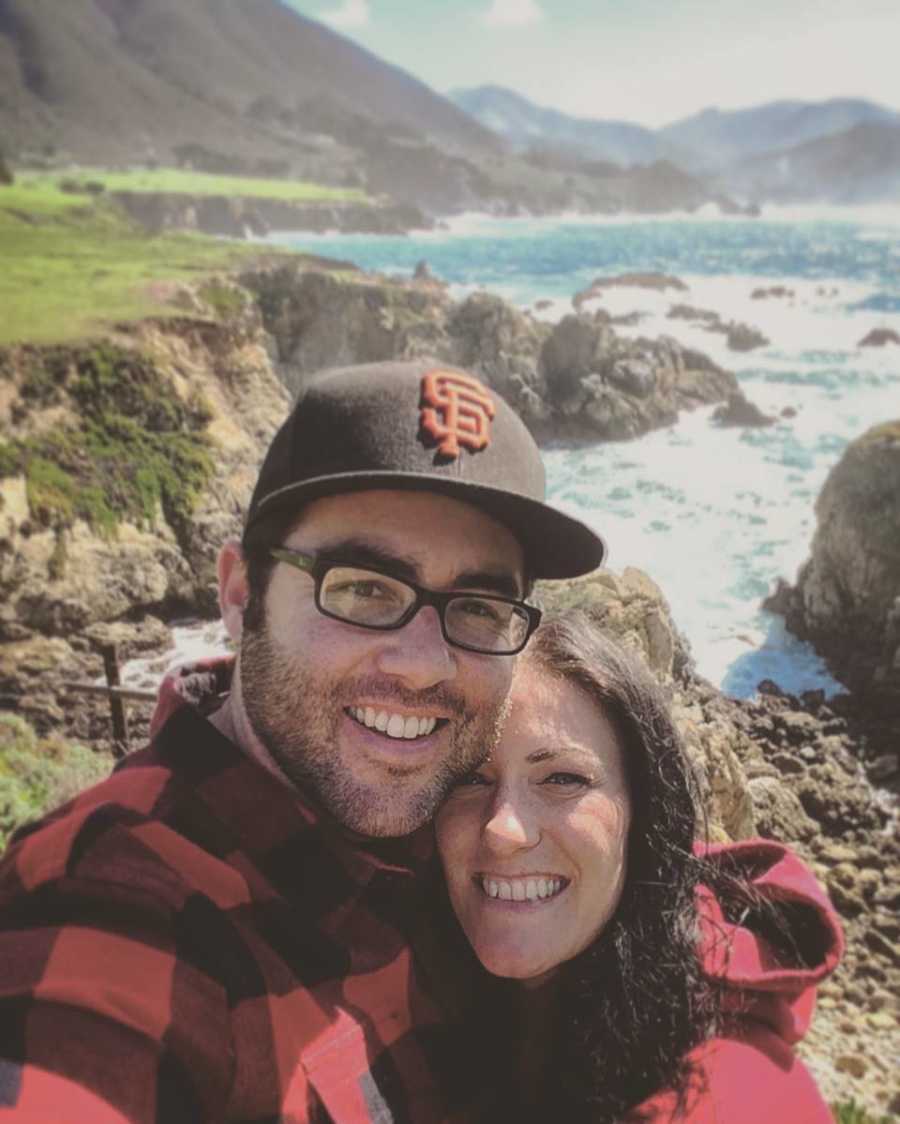 Man smiles in selfie with soulmate who has since passed away with cliffs and body of water in background