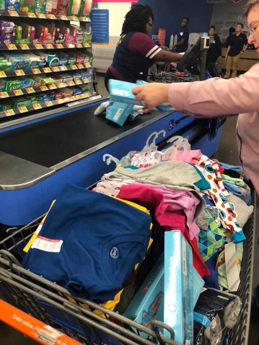 Woman checking out at Walmart with an overflowing cart for those affected by Hurricane Florence