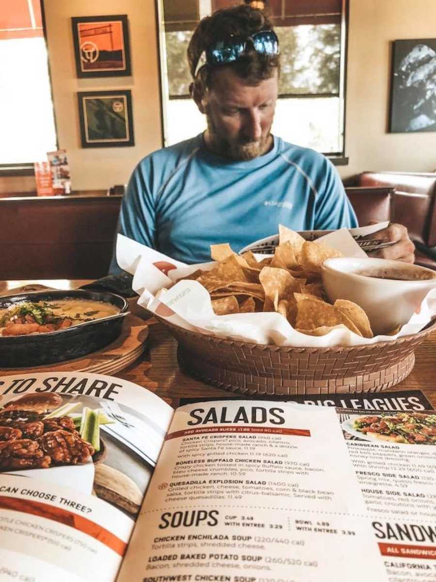 Husband sitting in booth of restaurant whose wife says it's okay for women to depend on their husbands