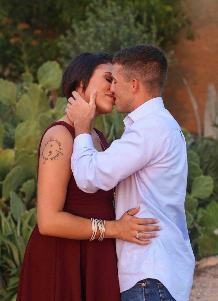 Husband and wife stand kissing