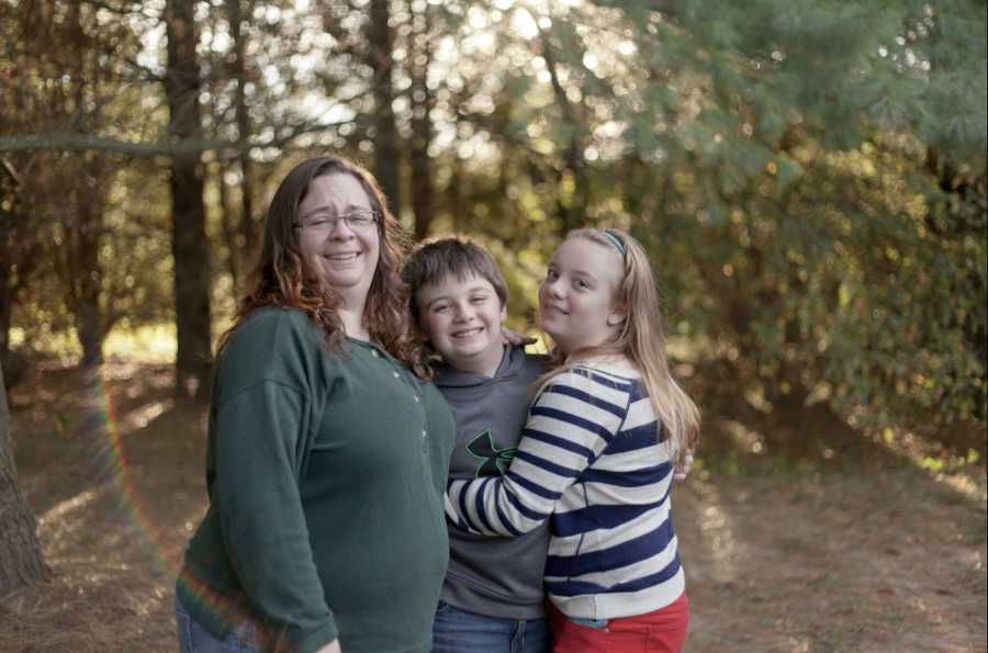 Mother who was ashamed of her weight smiling with son and daughter in wooded area