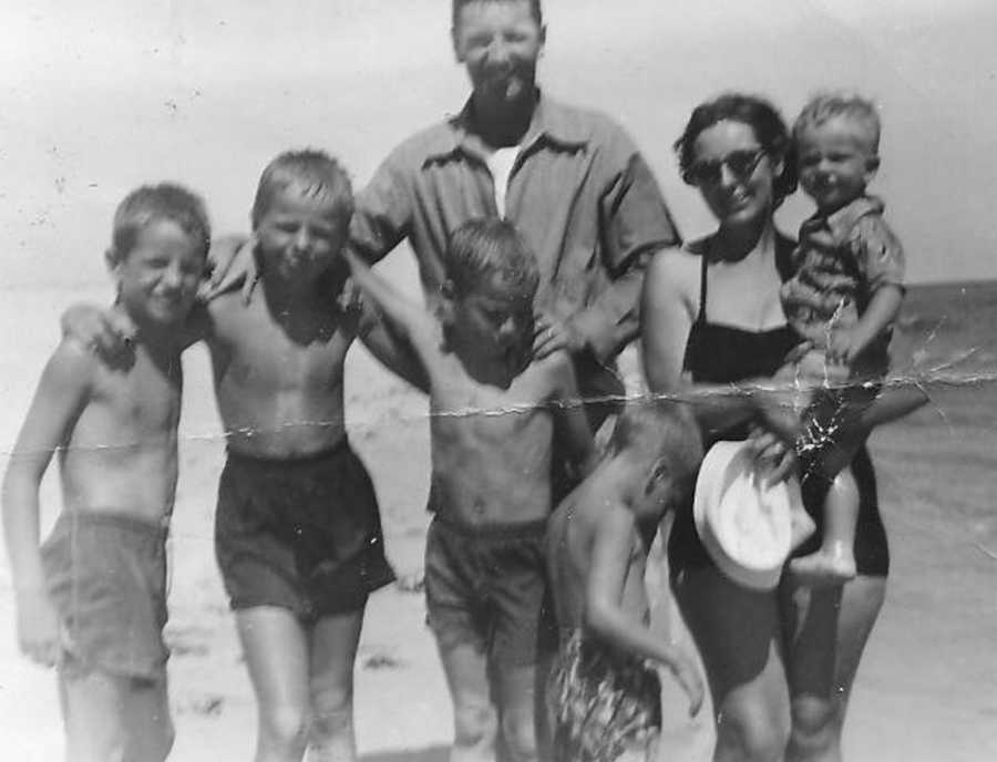 Husband and wife at the beach when they were younger with their five sons