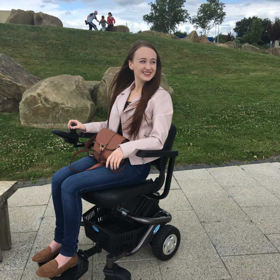 Young woman with disability smiling in electric wheel chair