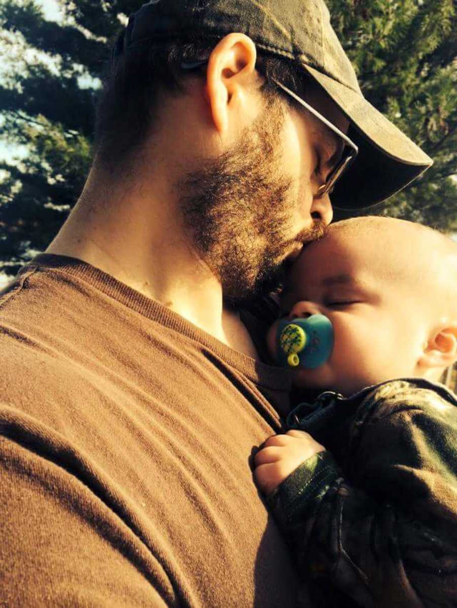 Father holds and kisses son on forehead who underwent brain injury