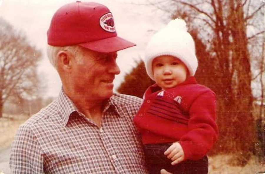 Grandfather smiling while holding granddaughter when she was a baby