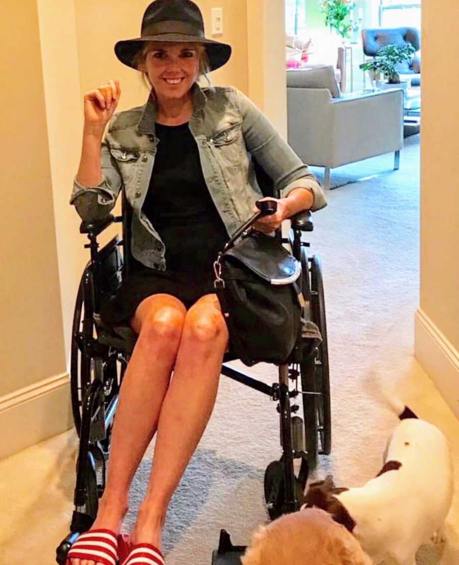 Woman who almost died giving birth smiles while sitting in wheelchair in home with dogs at her feet