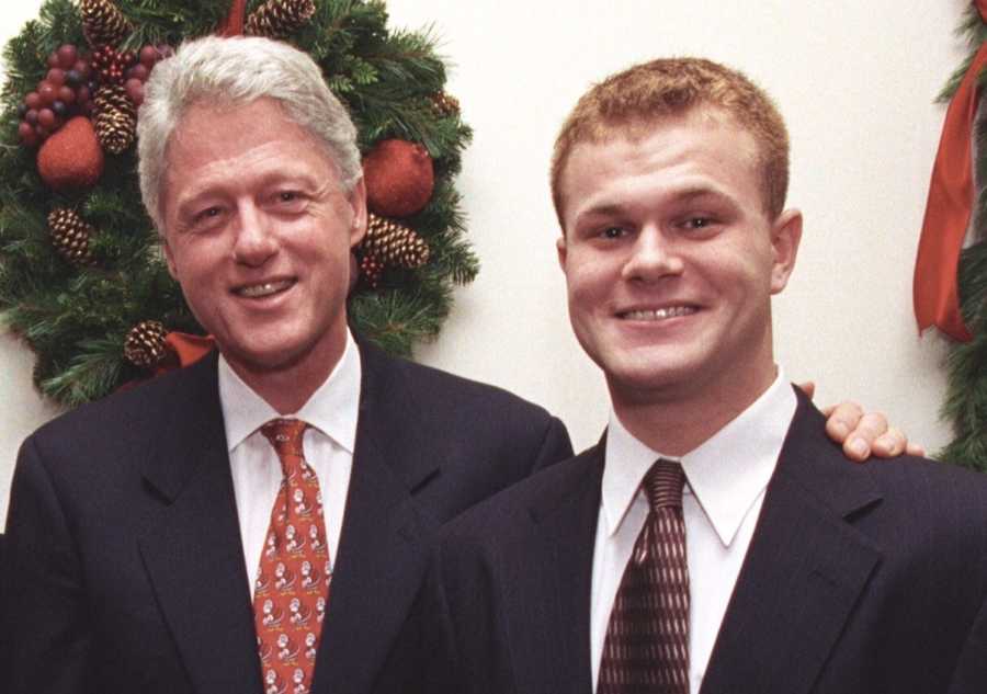 Man who was a junkie and now activist stands smiling beside Bill Clinton