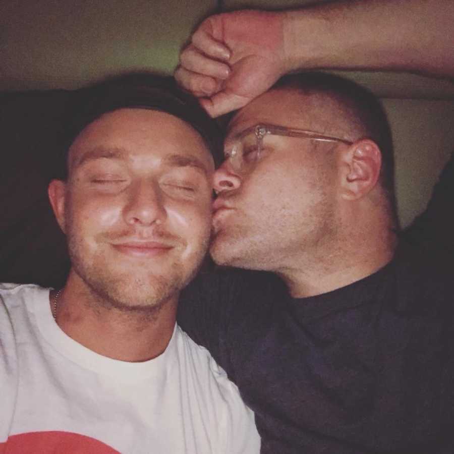 Man who was once a junkie and is now an activist kisses another man on cheek in selfie