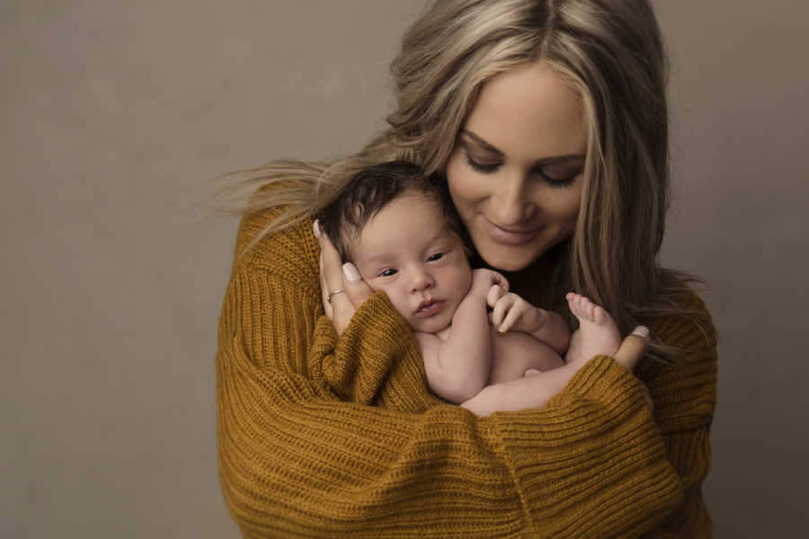 Mother holds newborn in her arms whose twin was absorbed in womb