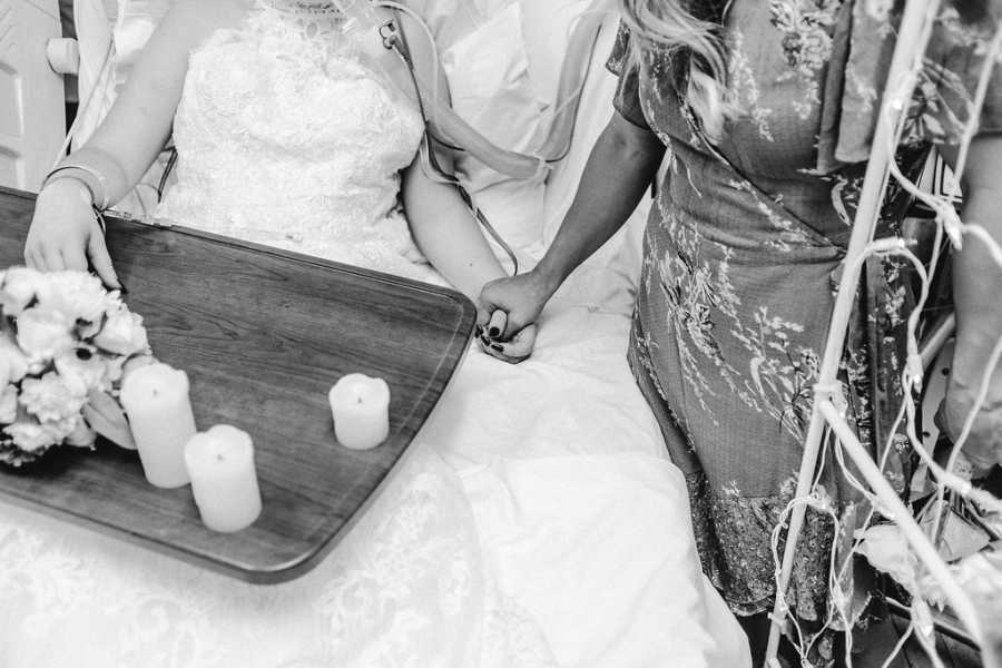 Teen with cancer wears wedding gown in hospital bed holding mothers hand