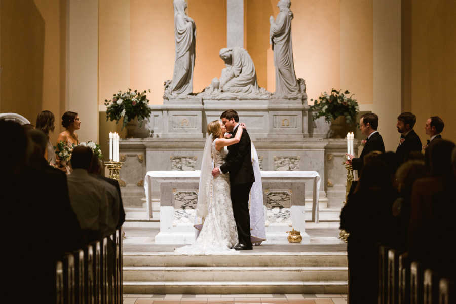 Bride and groom share first kiss at wedding ceremony in church where her grandparents were married