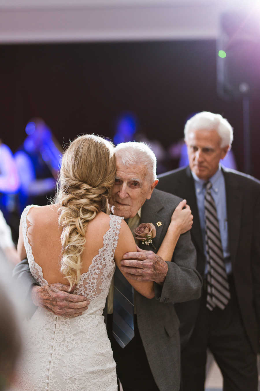 Grandfather hugs granddaughter while dancing at her wedding