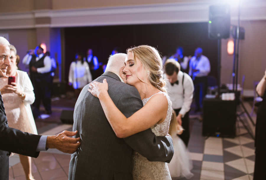 Bride closes her eyes as she dances closely with her grandfather at her wedding
