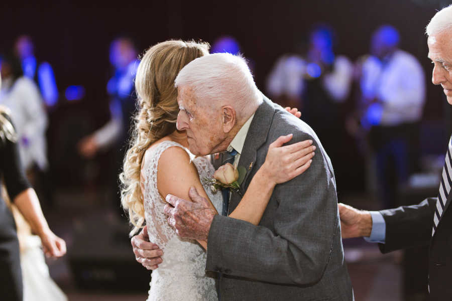 Grandfather holds granddaughter closely as they dance at her wedding