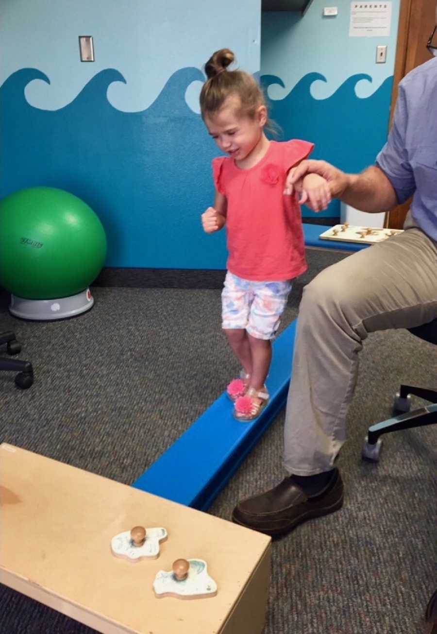 Toddler who had shaken baby syndrome in therapy walking on balance beam