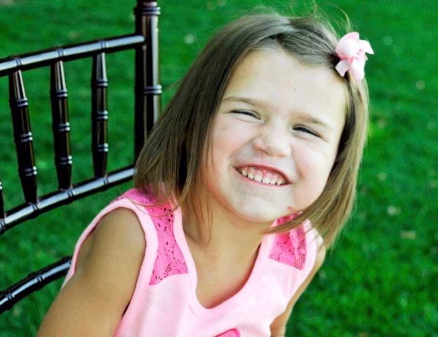 Toddler who had shaken child syndrome smiling while sitting in chair outside