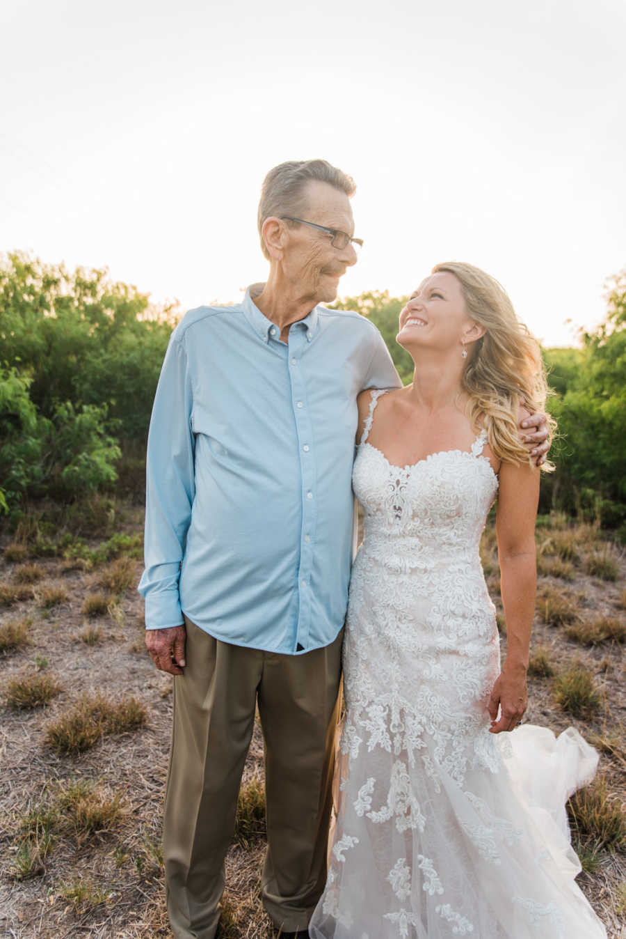 Woman stands in wedding dress with father who was diagnosed with cancer and wouldn't be able to make her wedding