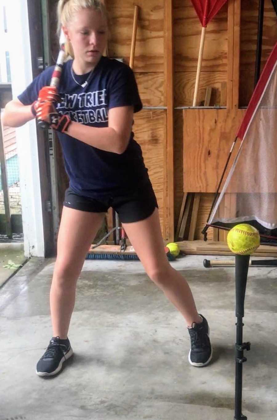Teen who was told she had gained too much weight at physical stands with bat and softball tee