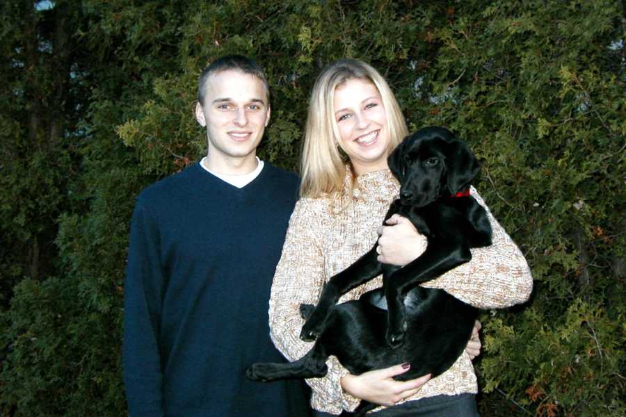 Man and wife who has since passed stands holding a puppy when they were younger