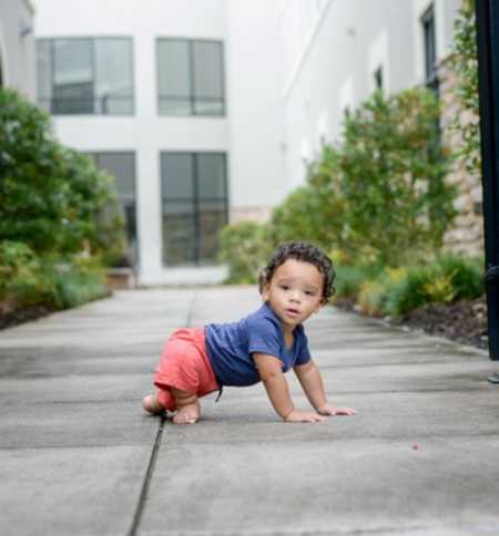 Foster child who may have fetal alcohol syndrome crawls on sidewalk