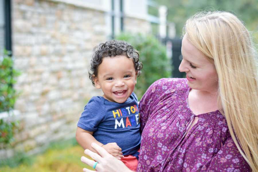 Mother smiles at adopted son she is holding who has an undiagnosed disease