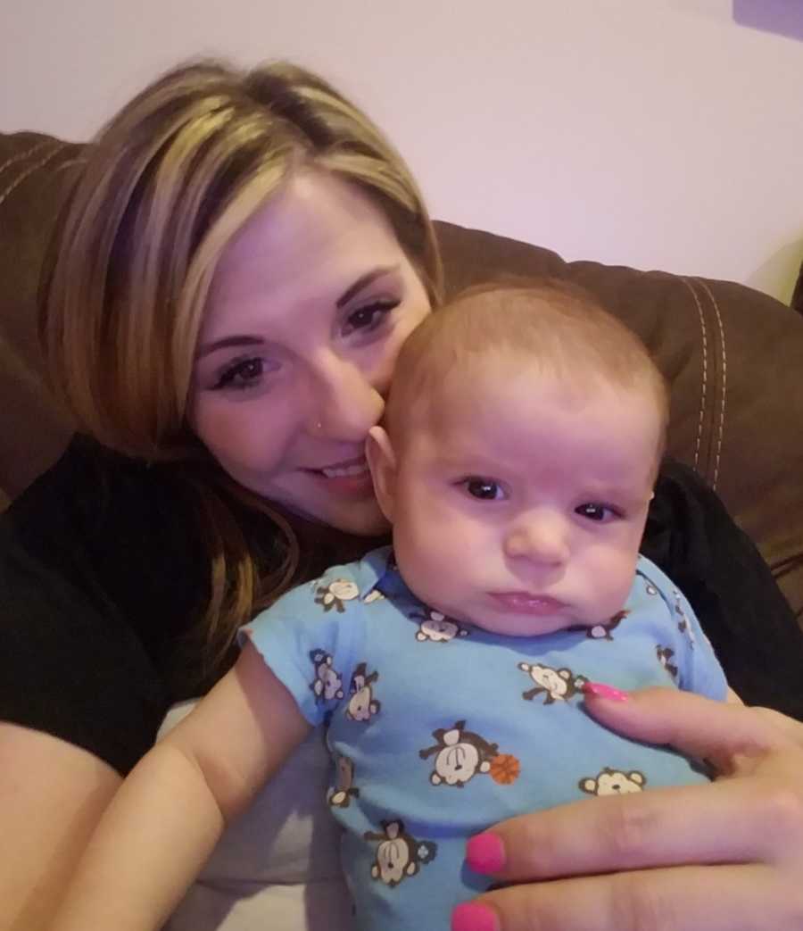 Mother sits smiling with infant on her lap who will die from SIDS