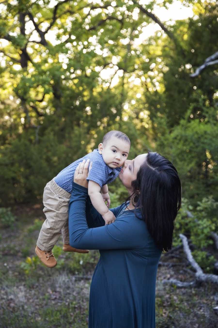 Woman who had a meltdown in Target fitting room over body stands in woods holding up son