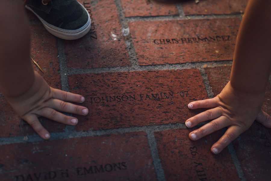 Little kids hands on brick that says, "Johnson Family '07" for father who passed away