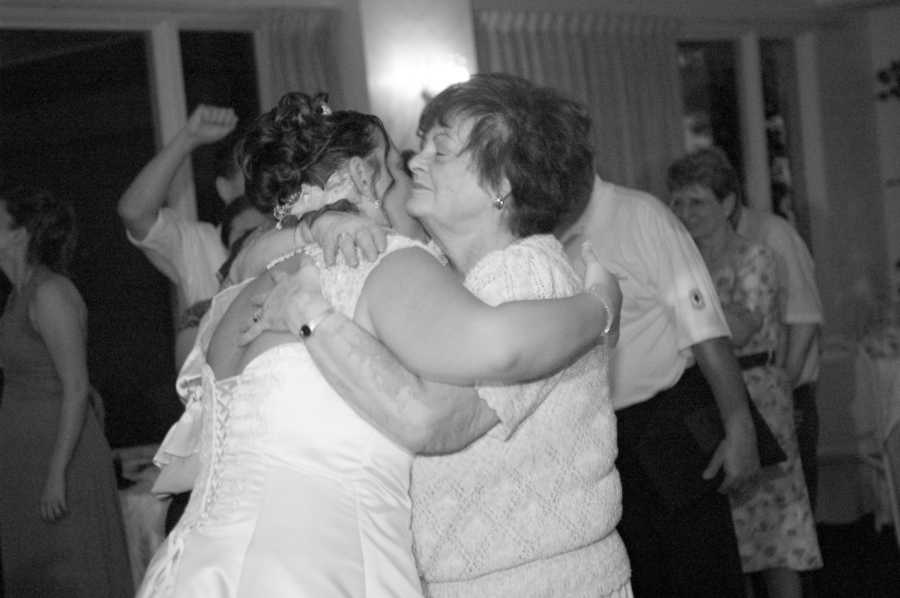 Bride hugging woman at wedding reception