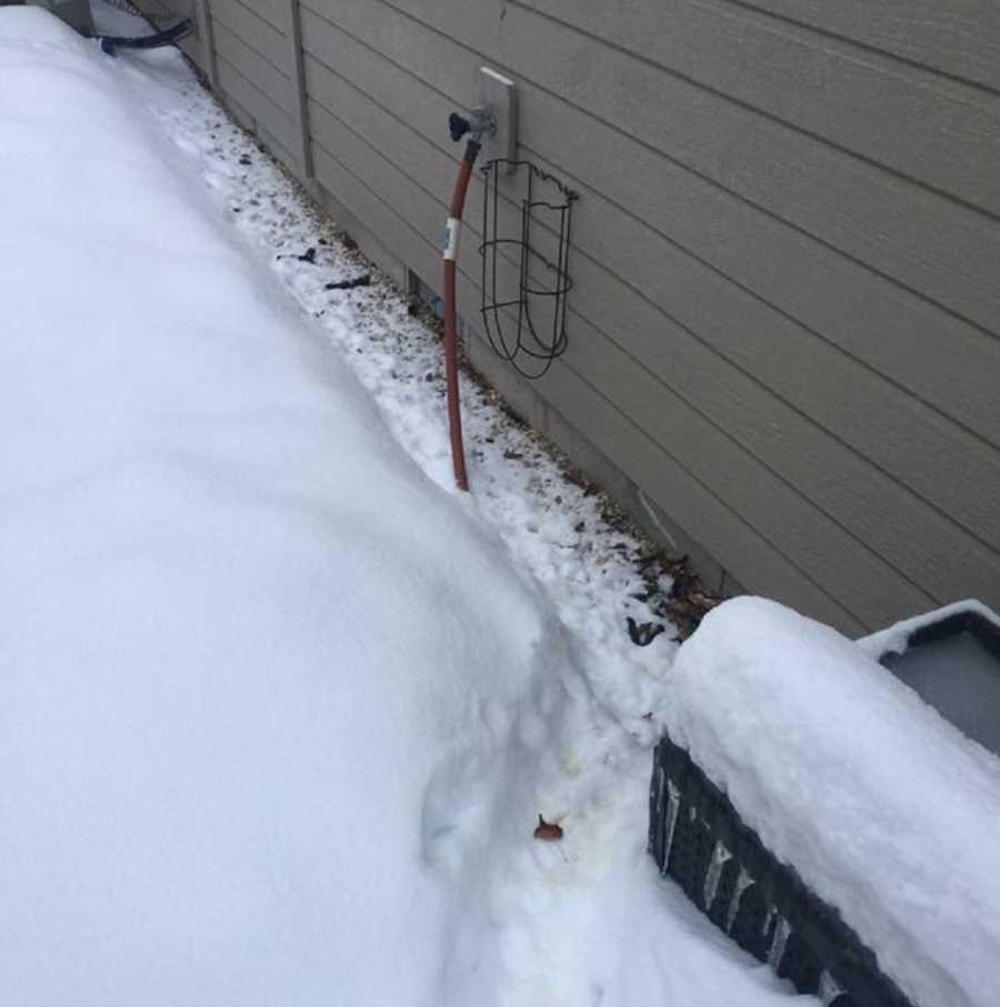 Hose hooked up to house covered in snow