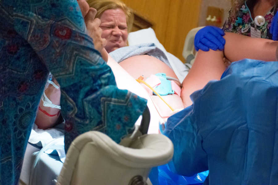 Woman in fetal position as she gives birth