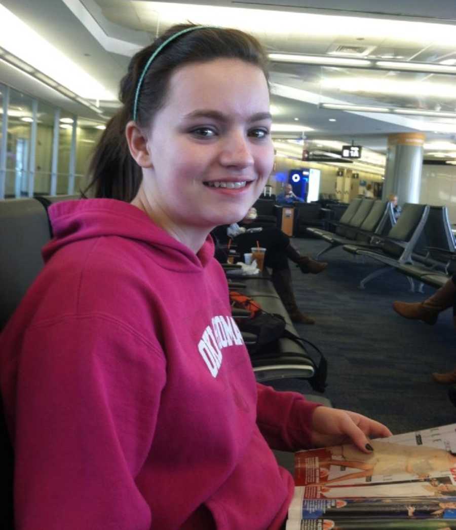 Teen with social anxiety and depression smiles in airport while reading magazine
