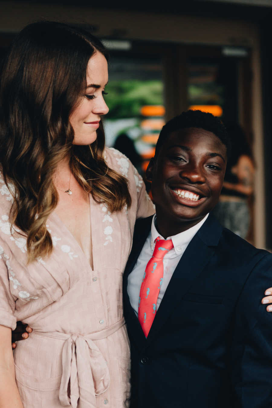 Woman smiles with arm around adopted son's biological brother