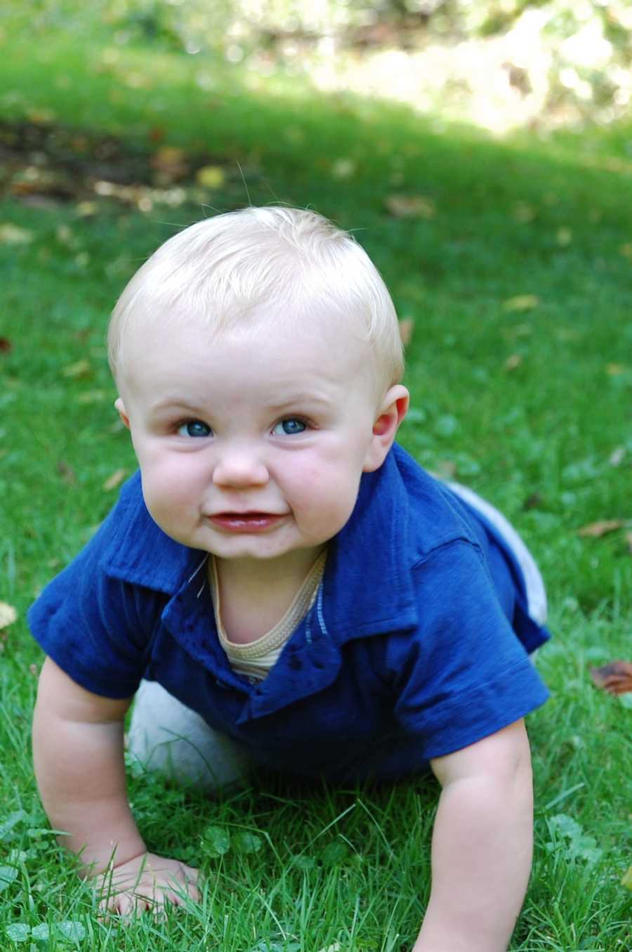 Baby crawling in grass who is different from other babies his age