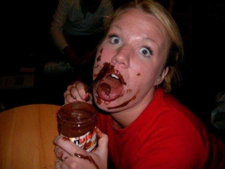 Teen who was bullied at school poses with mouth open holding Nutella as she spreads it on her face