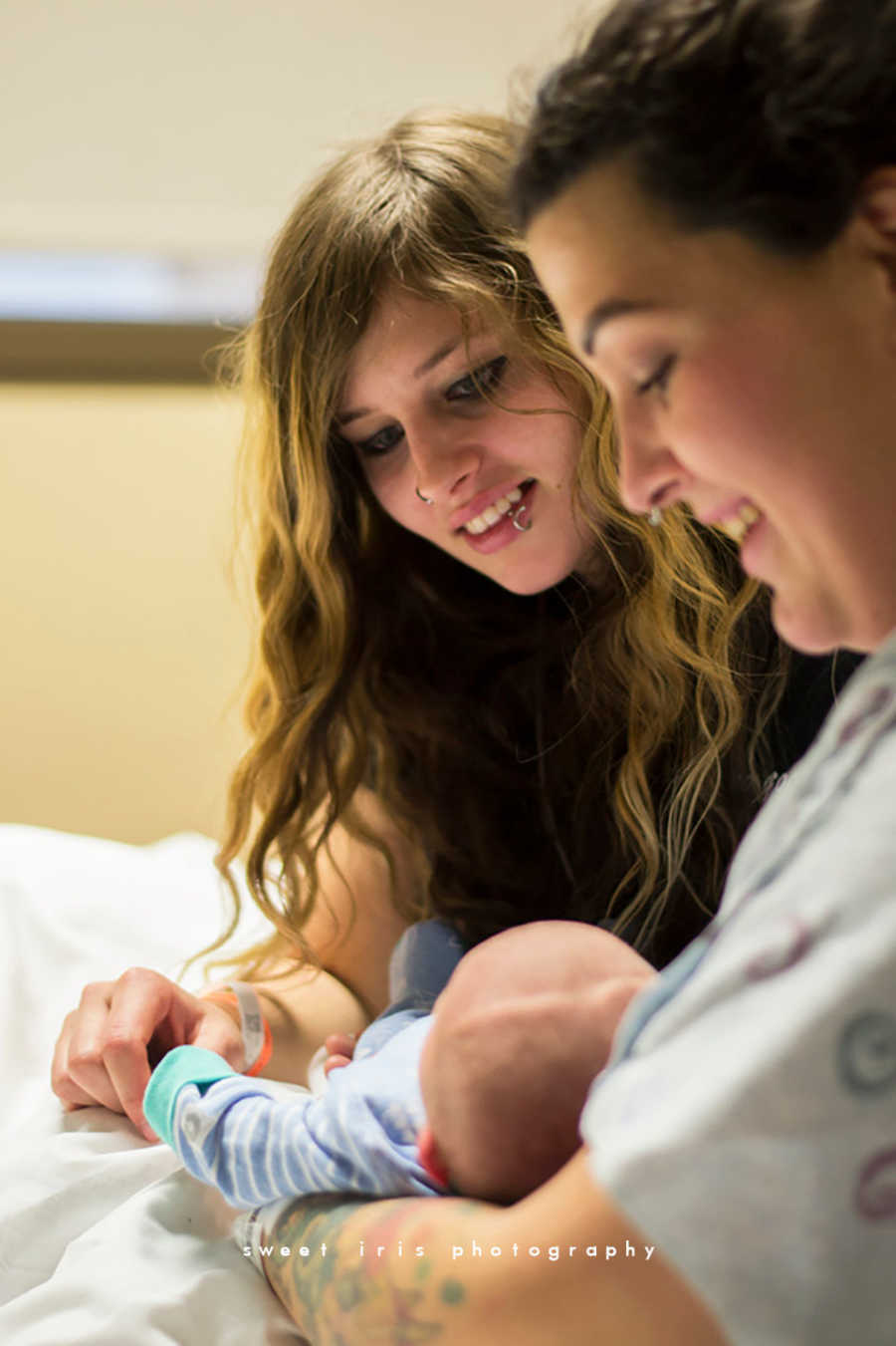 Wife's smile down at their newborn