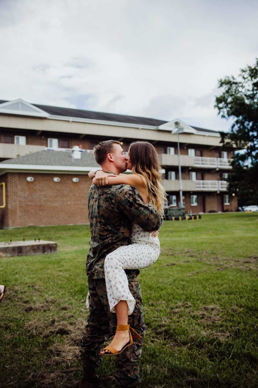 Army husband holds and kisses wife as he returns home from deployment