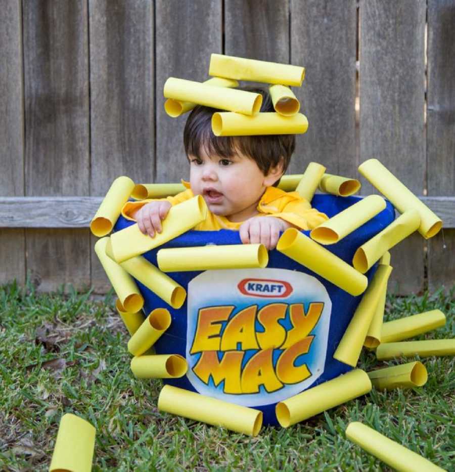 Young boy sitting outside in easy mac costume