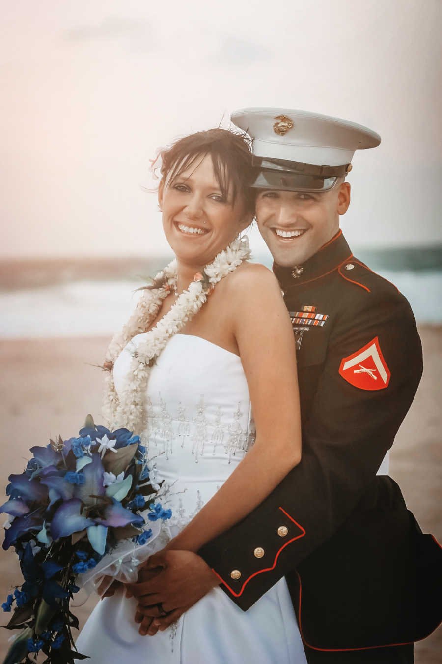 Bride and marine groom stand hugging on their wedding day