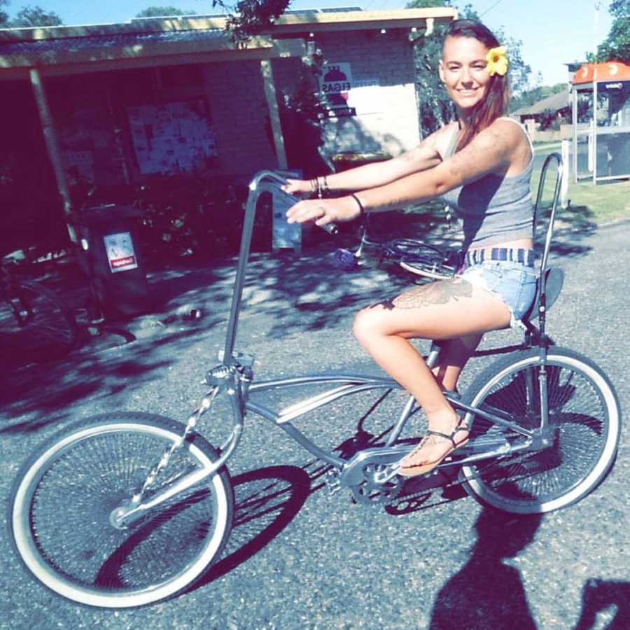 Woman recovering from mental health struggles smiles as she rides bike