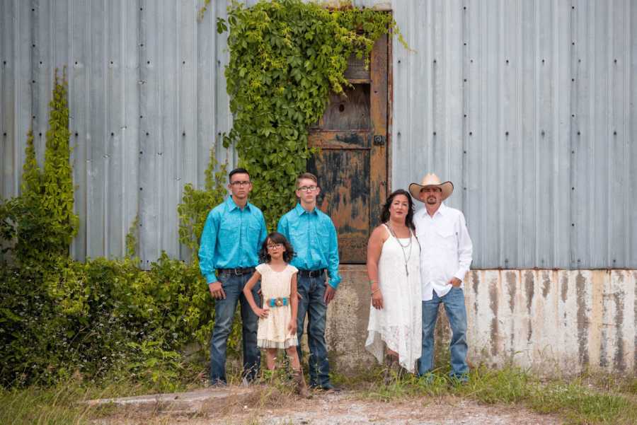 Husband and wife who just renewed vows stand arm in arm with their three children to the left of them