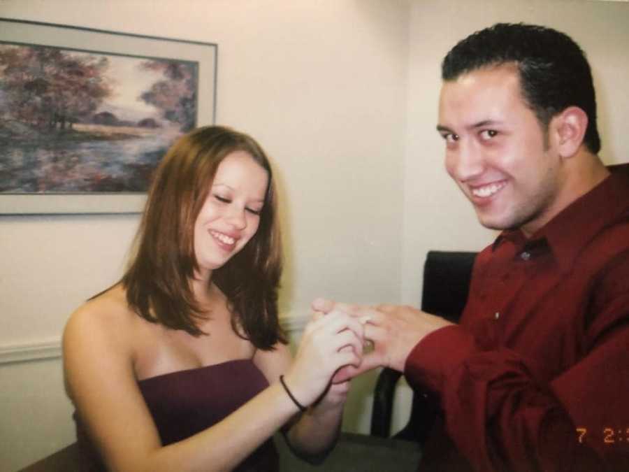 Husband smiling as his wife places ring on his finger