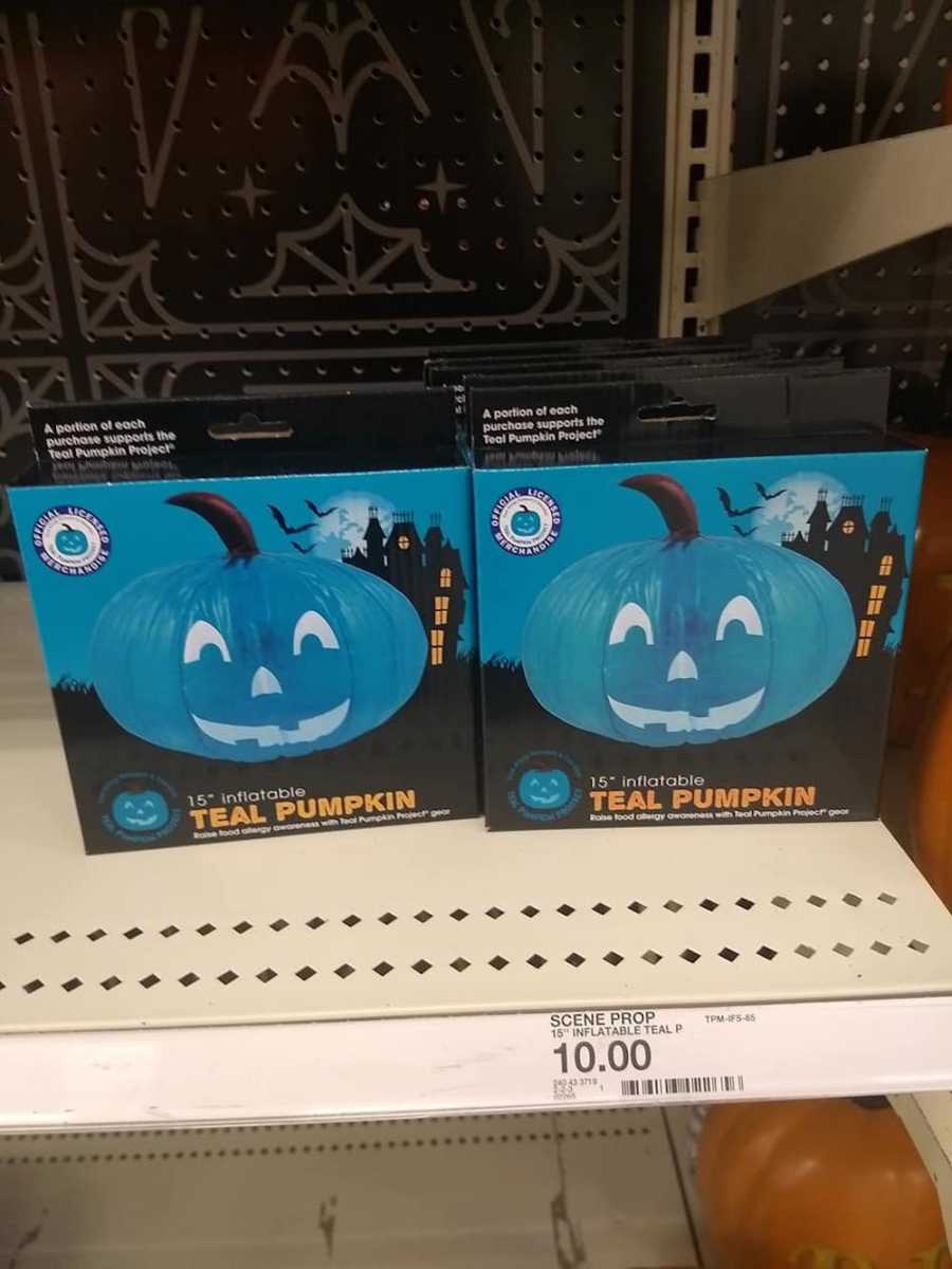 Two boxes of teal jack-o-lanterns on shelf of store