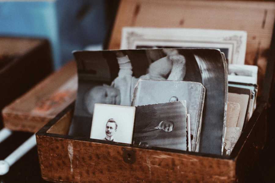 Wooden box filled with old photographs of woman's husband and deceased child
