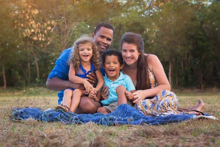 Woman sits on blanket outside with her two children and husband before he passed