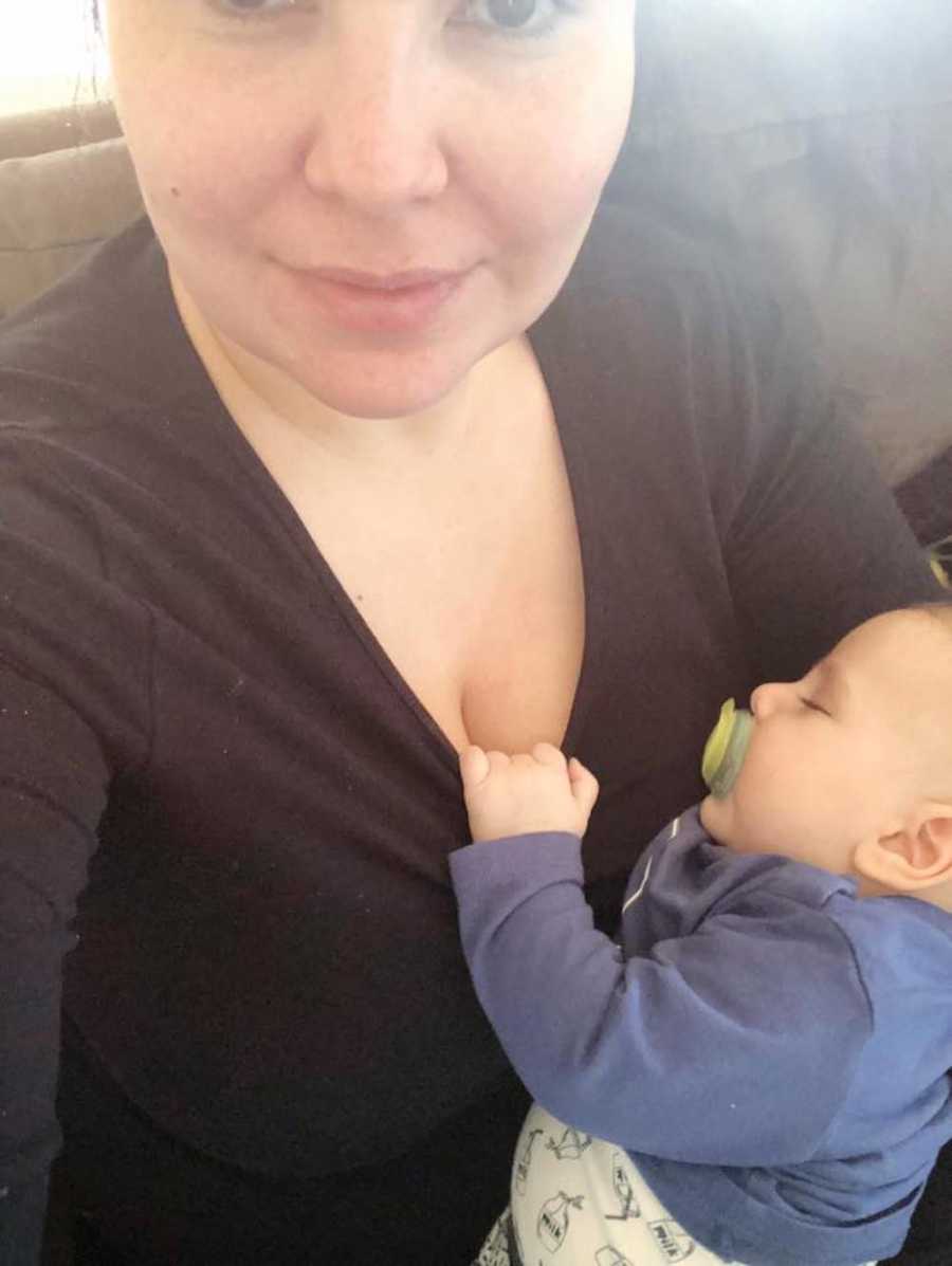 Mother who is just as mentally tired as physically at end of day smirks in selfie with baby in her arms
