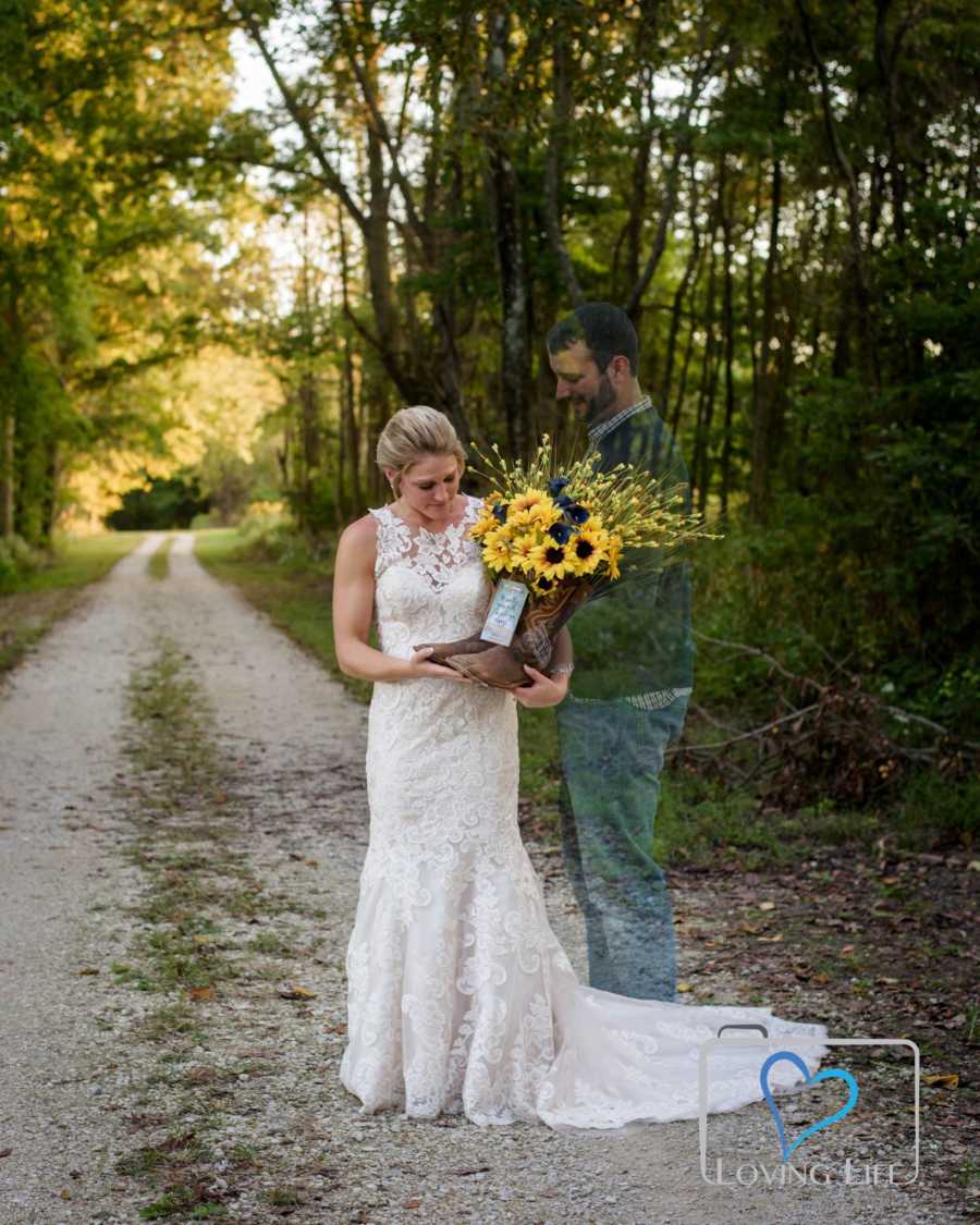 Woman stands in wedding gown holding cowboy boots with flowers in them for deceased husband