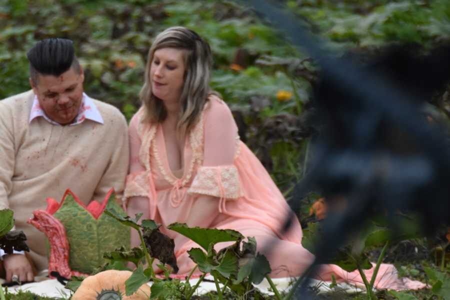 Husband and wife look down admiringly at bloody creature that came out of her stomach